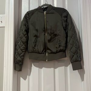 Green jacket with pockets and a diamond pattern down the sleeve with a zipper